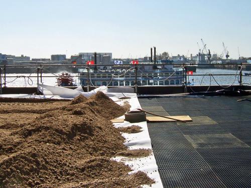 Substratschüttung auf einem Dach und Boot im Hintergrund