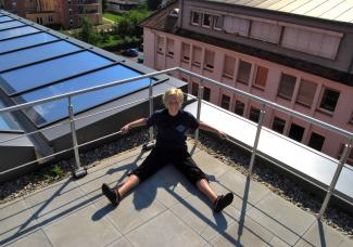 Person vor Geländer auf Dachterrasse