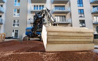 Bagger auf einer Substratfläche in einer Wohnanlage