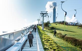 Gründach mit Skifahrern und Treppenaufgang