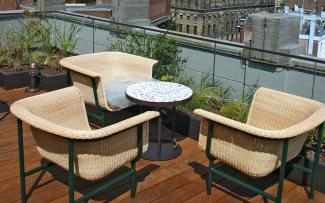 Dachterrasse mit Holzbelägen und Korbstühlen