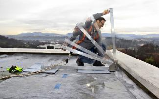 Montage des Arbeitsschutzgeländers Fallnet® ASG auf dem Dach